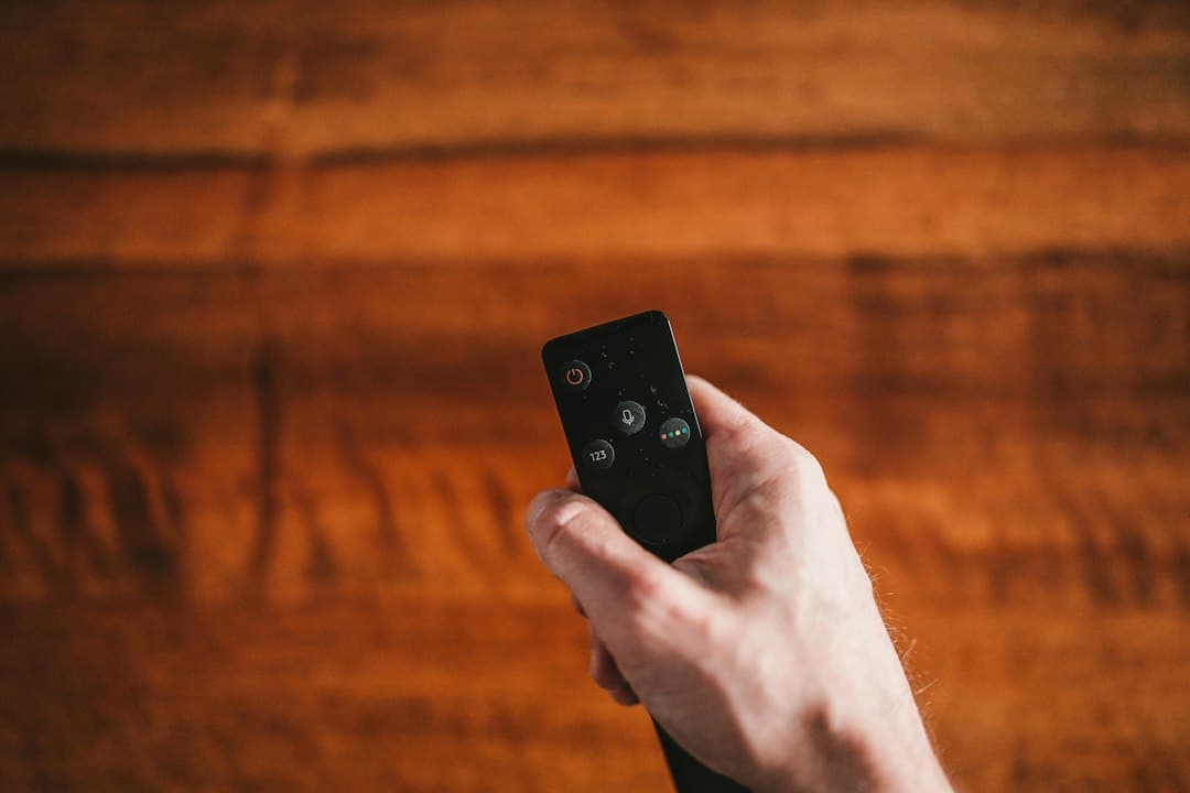 Person med fjernbetjening foran tv – gratis IPTV-prøveperiode